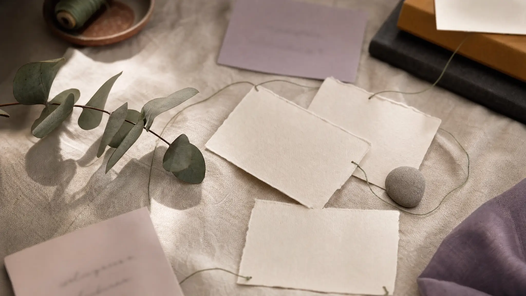 Editorial photo: a couple's hands holding a smartphone on cream linen, with herbal tea and dried plants nearby
